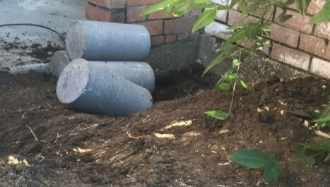 Concrete piers are pressed into the ground.