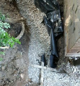 French drain being installed around a foundation.