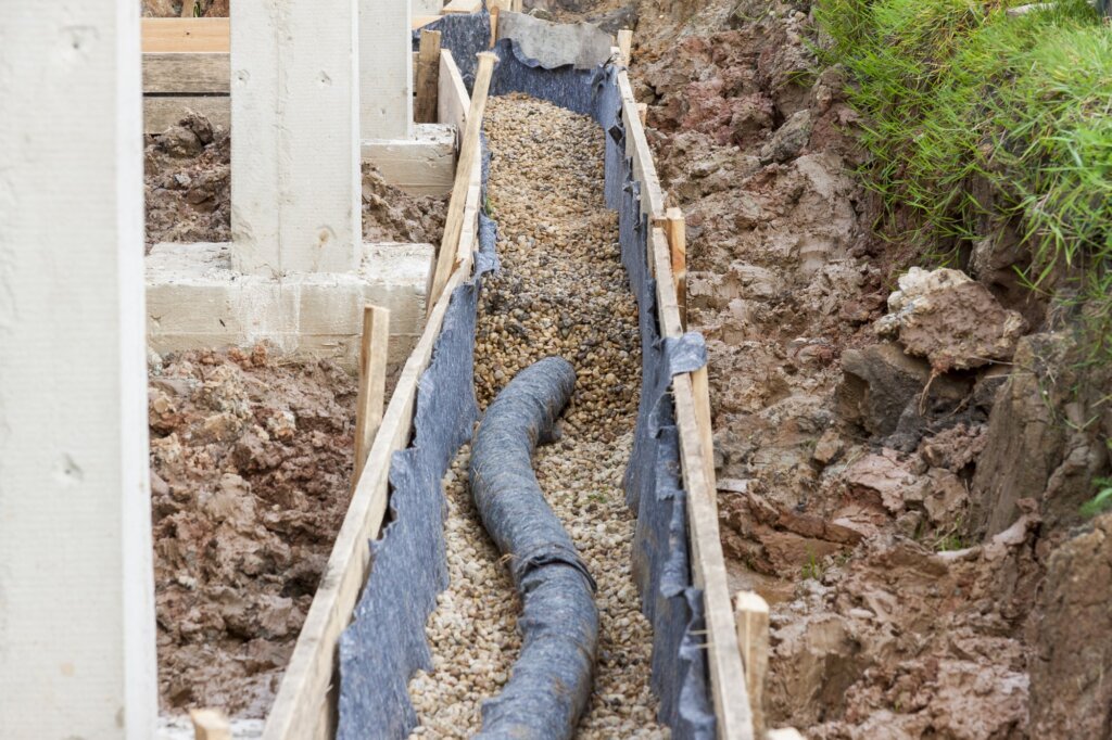 foundation drainage in DFW home A picture of a foundation drainage in DFW halfway filled with soil