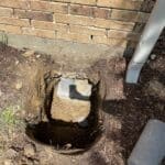 Steel foundation pier installed beneath a home to stabilize a settling foundation