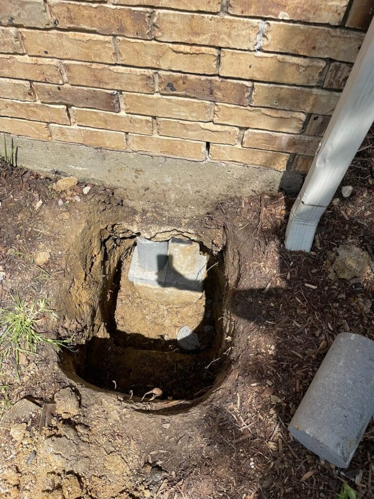 Steel foundation pier installed beneath a home to stabilize a settling foundation