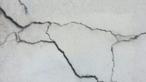 Severe wide branching cracks in a concrete foundation surface indicating major structural movement and damage