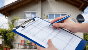 Inspector holding a checklist in front of a home during a spring foundation inspection.